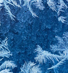 Frosty winter pattern at a window glass, macro texture