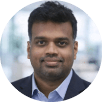 A man wearing a blue shirt and a black suit. Description generated by AI