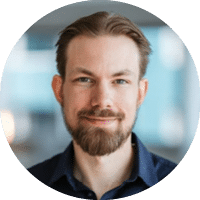 A man with a beard and mustache wearing a blue shirt. Description generated by AI