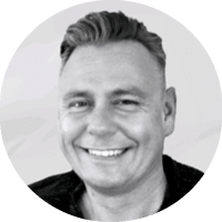 A man with a black shirt and a smile on his face. Description generated by AI