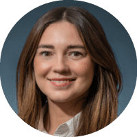 A woman with long brown hair and a white shirt. Description generated by AI