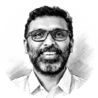 A man with a beard and glasses smiling. Description generated by AI