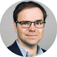 A man wearing glasses and a blue shirt. Description generated by AI