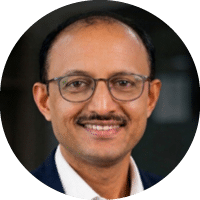 A man wearing glasses and a blue shirt. Description generated by AI