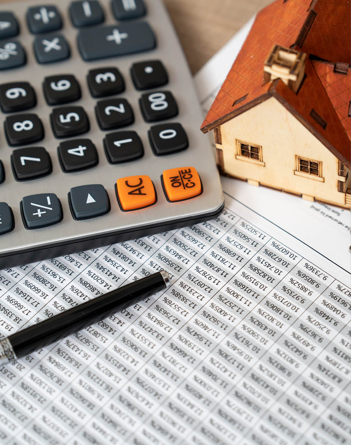 A calculator, a house, and a key are placed on top of a piece of paper. AI generated content