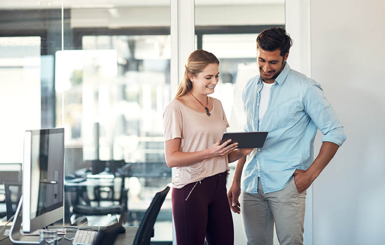 Shot of a businessman and businesswoman using a digital tablet together in a modern office