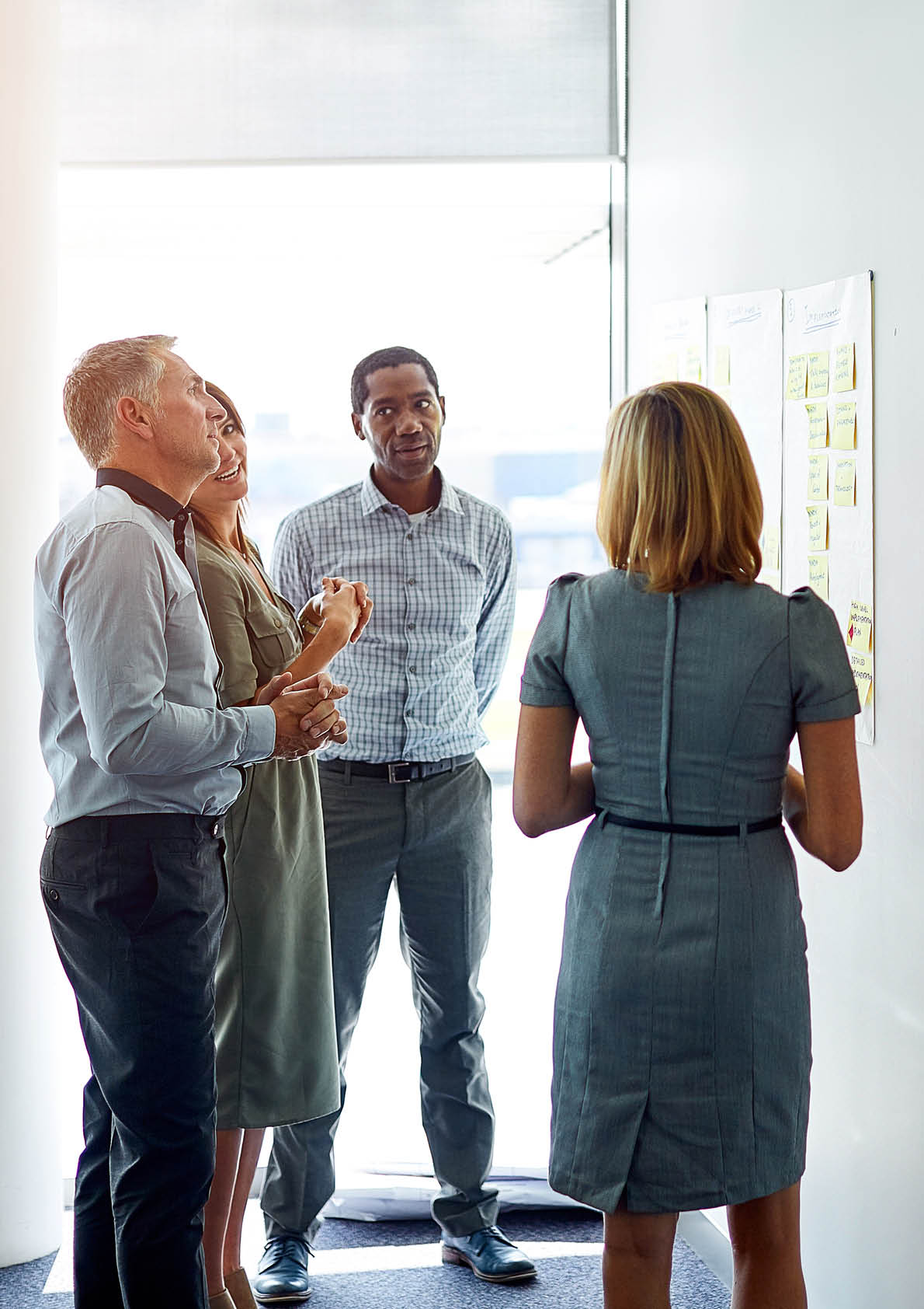 Cropped shot of a group of business colleagues gathered around a whiteboard in an office