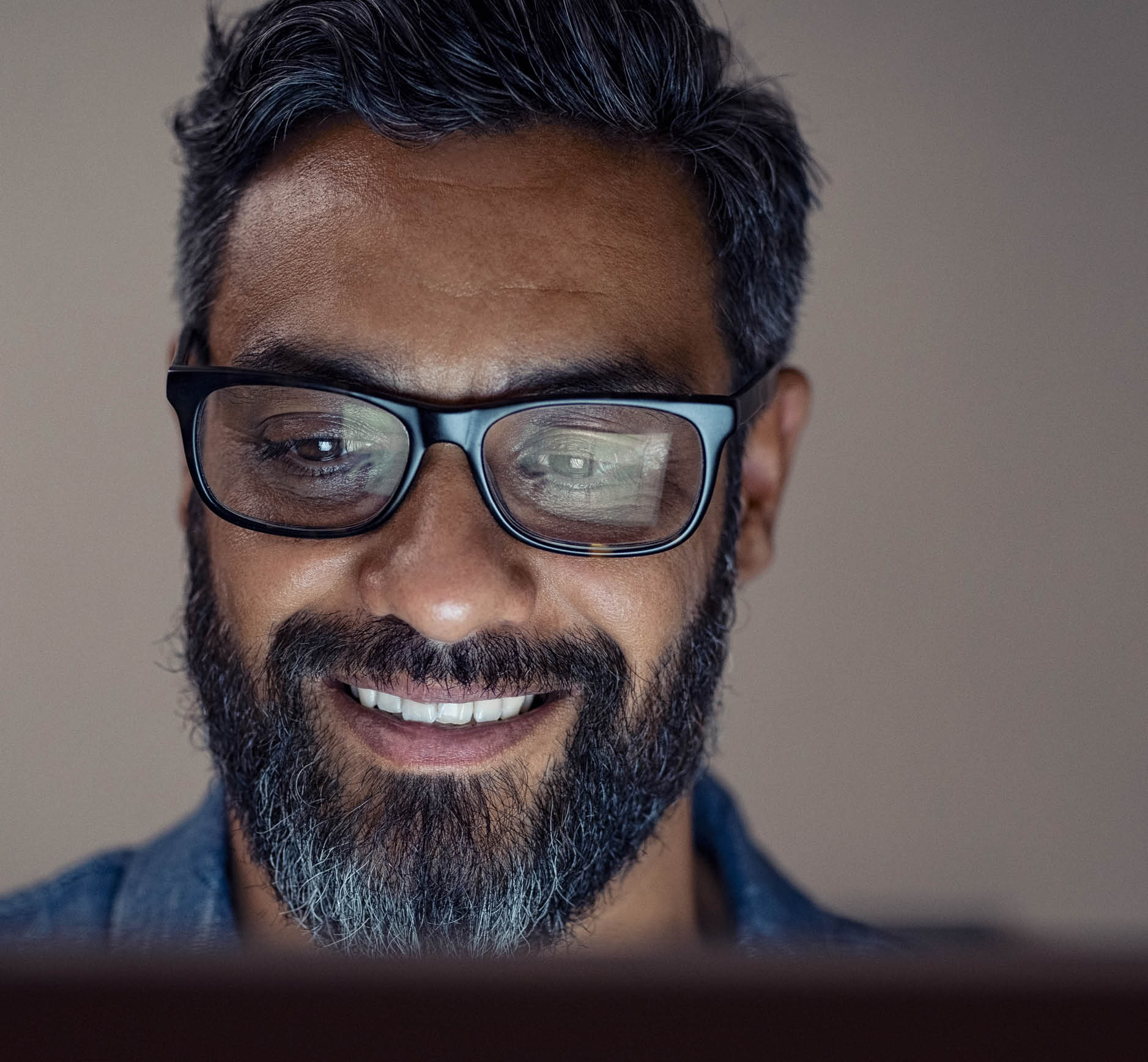 Latin man working on computer at night in dark office  Portrait of handsome hispanic businessman wearing glasses working with laptop  Closeup face of indian man using digital tablet in the evening 